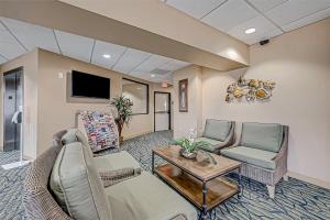 a living room with a couch and chairs and a tv at A Slice of Seawall in Galveston