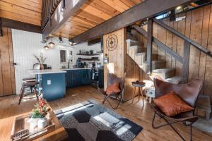a living room with a staircase and a kitchen at Bearadise - Prime location for a family getaway in the winter or summer in Big Bear City