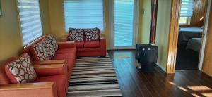 a living room with two red couches and a wood stove at Cabañas Quimantu-Aguas Calientes in Puerto Varas