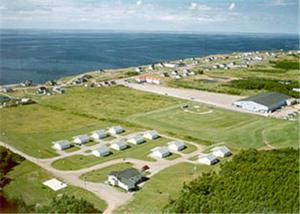 an aerial view of a group of houses and the ocean at Cabot Trail Sea & Golf Chalets in Chéticamp