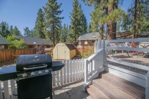 een barbecue naast een wit hek bij Southern Comfort - Light and bright Fox Farm country beauty with all of the amenities of a home! in Big Bear Lake