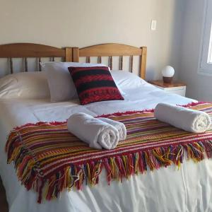 un letto con asciugamani e cuscini sopra di Andalue a San Carlos de Bariloche