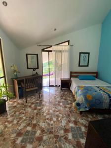 um quarto com uma cama, uma secretária e uma janela em Villa Pura Vida em Matapalo