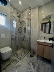 uma casa de banho com um chuveiro, um WC e um lavatório. em Donna em Ulcinj