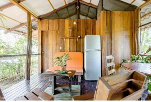 a kitchen with a refrigerator and a table and chairs at Luminosa Uvita Hostel in Uvita