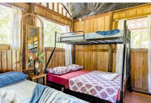 a bedroom with two bunk beds and a mirror at Luminosa Uvita Hostel in Uvita