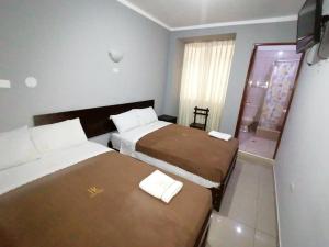 HOSTAL ROGGERIO SRL في بارانكا: غرفة فندقية بسريرين ونافذة