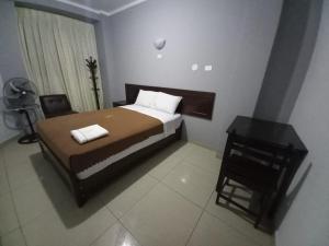 Dormitorio pequeño con cama y mesa en HOSTAL ROGGERIO SRL, en Barranca