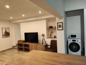 a living room with a flat screen tv and a couch at Apparthotel La Livinière in La Livinière