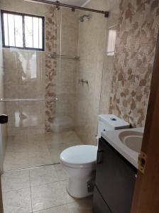 een badkamer met een toilet, een douche en een wastafel bij Habitación la Estación. in Paipa