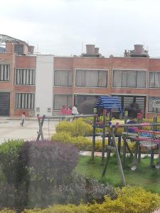 een groep picknicktafels voor een gebouw bij Habitación la Estación. in Paipa