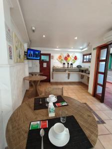 een woonkamer met een tafel en een keuken bij Hotel Los Lapachos in Puerto Iguazú