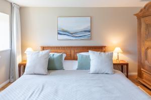 a bedroom with a bed with white sheets and pillows at De ole Hüs 1735 in Braderup