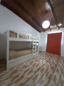 Habitación con 2 literas y suelo de madera. en Cabaña La Agostina en Mina Clavero