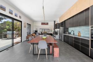 a kitchen with a wooden table and a dining room at Stage 1 in Point Lonsdale