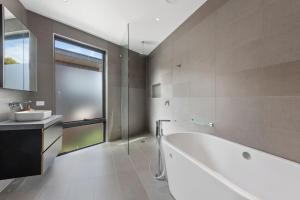 a bathroom with a white tub and a sink at Stage 1 in Point Lonsdale +16 photos