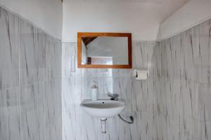 y baño con lavabo y espejo. en Mahendra Cottage, en Nusa Penida