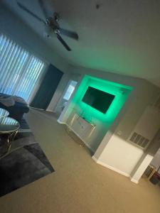 a living room with a green light on the wall at Loftly Luxury Modern Oasis 2BR 2BA apartment Windermere FL, near Disney, Universal Studios, Magic Kingdom, Pool, Gym, Patio, free cable, wifi, free parking, gym, Alexa, lake, gated community, spacious closets, close to shops and mall in Orlando