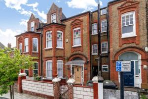 a large brick building with a parking sign in front of it at One bedroom flat in the heart of Brixton in London