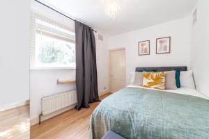 a bedroom with a bed and a window at One bedroom flat in the heart of Brixton in London