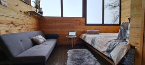 a room with a couch and a table and windows at Tiny House Jaulares in Rivas
