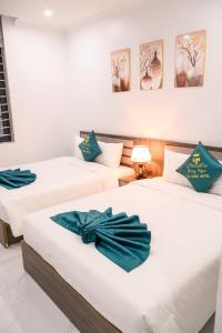 Giường trong phòng chung tại Hồng Ngọc Hạ Long Hotel +13 ảnh