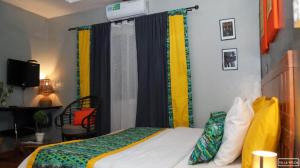 1 dormitorio con 1 cama con cortinas coloridas en Villa Wilda, en Bamako