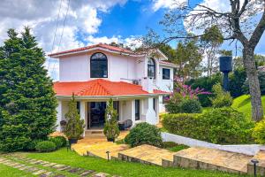 ein weißes Haus mit orangefarbenem Dach in der Unterkunft Casa com WiFi e otima localizacao em Sao Roque SP in São Roque