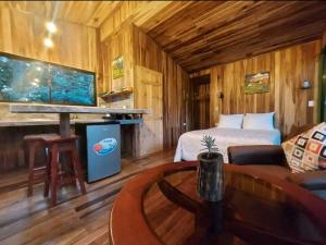Dormitorio con cama y escritorio con pecera en Jungle Living Tree Houses en Monteverde Costa Rica