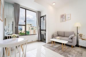a living room with a couch and a table at TeeUp Home - Infinity Pool Signature in Ho Chi Minh City