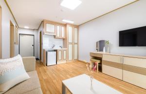 a living room with a couch and a tv at Seogwipo Worldcup Resort in Seogwipo