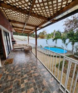 un patio al aire libre con pérgola y piscina en Casa en condominio cerca de la playa El Quisco Norte, en El Quisco