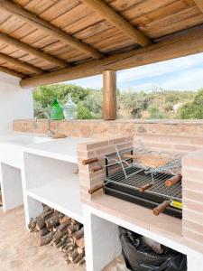 une cuisine extérieure avec un barbecue sur une terrasse dans l'établissement Monte da Borrega - Casa de Campo, à Esperança