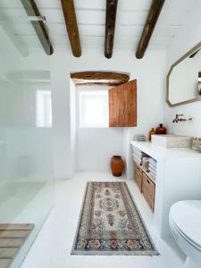 a bathroom with a sink and a toilet and a rug at Monte da Borrega - Casa de Campo in Esperança