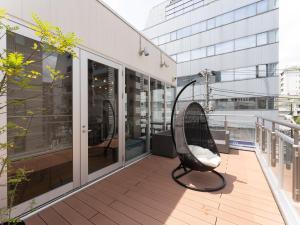 橫濱的住宿－Tabist MAYUDAMA CABIN，坐在大楼阳台的椅子