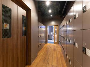 a hallway in a gym with lockers and a hallway at Tabist MAYUDAMA CABIN in Yokohama