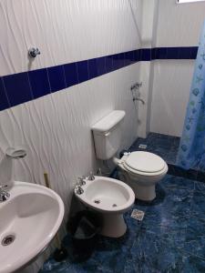 a bathroom with a white toilet and a sink at Hotel y Departamentos Arroyos in Perico