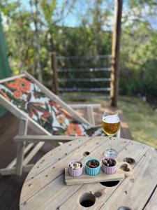 a glass of wine sitting on a wooden table with cupcakes at Alto da Villa Loft in Ouro Preto