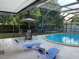 a swimming pool with two chairs and an umbrella at Airbnb rental in Miami