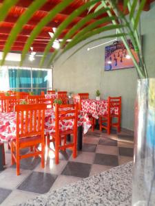 jadalnia z czerwonymi stołami i krzesłami w restauracji w obiekcie Cabañas Puertas del Sol w mieście La Rioja