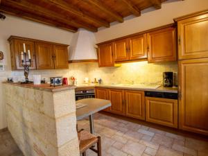 a kitchen with wooden cabinets and a counter top at Charmante maison avec WiFi, parking privé, jardin et ping-pong à Monpazier - FR-1-616-173 in Monpazier