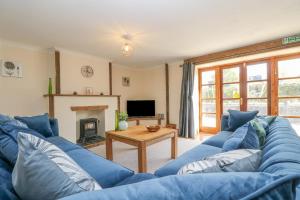 a living room with a blue couch and a table at The LinneyThe West Dry in St Austell