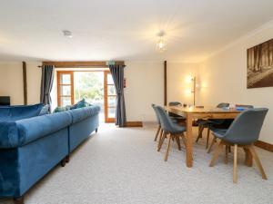 a living room with a blue couch and a table at The LinneyThe West Dry in St Austell