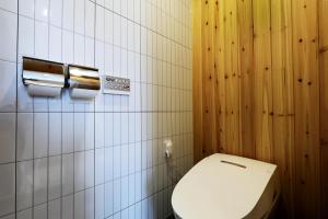 a bathroom with a white toilet and wooden walls at Hotel Intro Chuncheon in Chuncheon