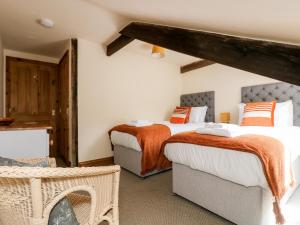 a bedroom with two beds and a table at Riverside in St Austell
