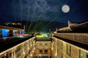 a view of a city at night with a full moon at Phoenix Hall House Hotel in Fenghuang