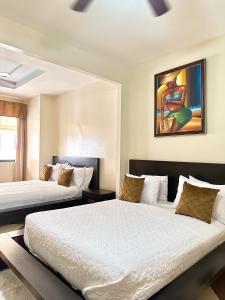 a bedroom with two beds and a painting on the wall at Aparta Hotel Roma in Santo Domingo