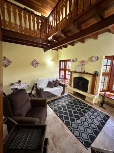 uma sala de estar com um sofá e uma lareira em Chalés Bela Vista em Monte Verde