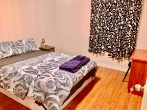 um quarto com uma cama com um edredão em CozyHome em Markham