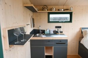 una cocina con 2 copas de vino en una barra en Sleep Space - Green Tiny Spot Steinhuder Meer en Neustadt am Rübenberge